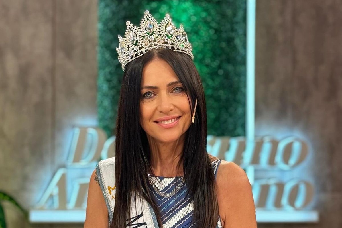 Foto colorida de mulher com coroa e faixa de miss - Metrópoles