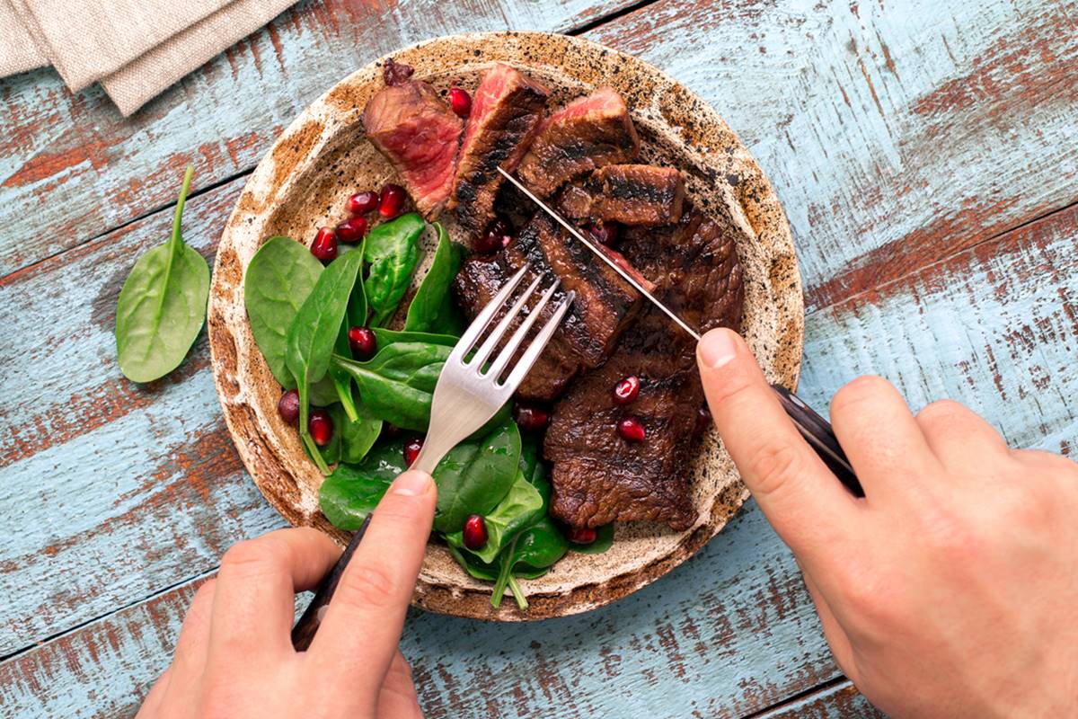 Foto colorida de tábua com carne e salada - Metrópoles