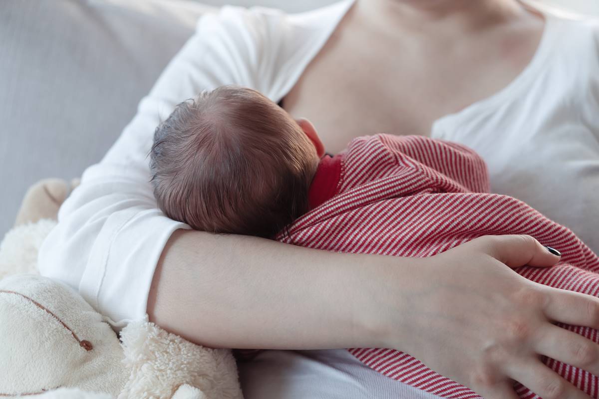 Foto colorida de uma mãe amamentando um bebê - Metrópoles