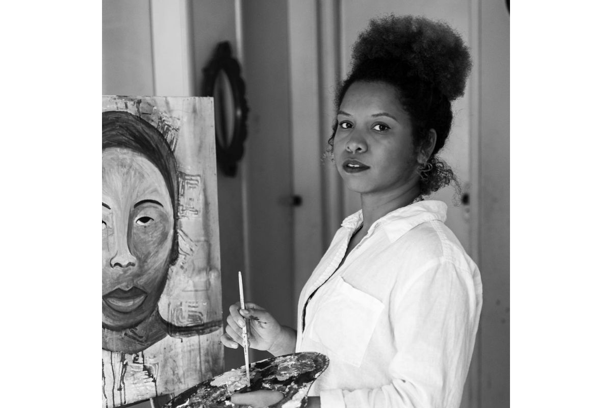 Foto em preto e branco de uma artista pintando quadro - Metrópoles