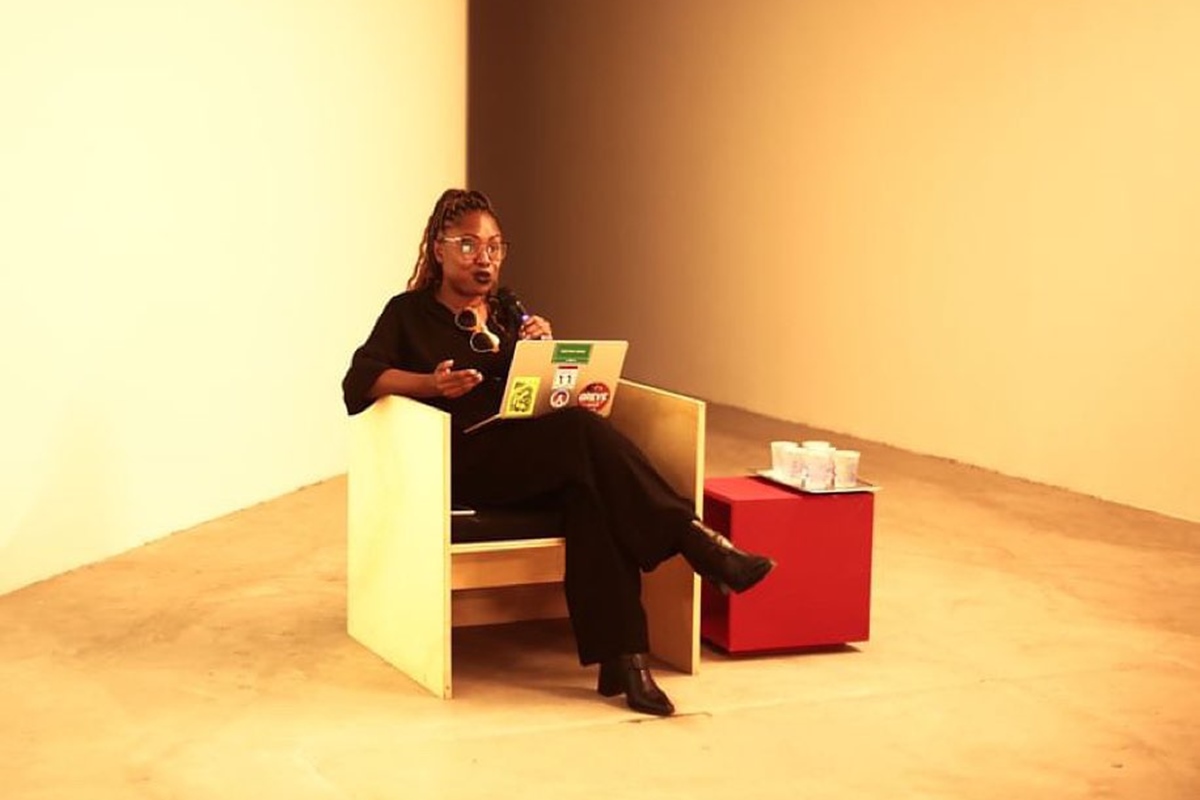 Foto colorida de mulher sentada e segurando notebook - Metrópoles