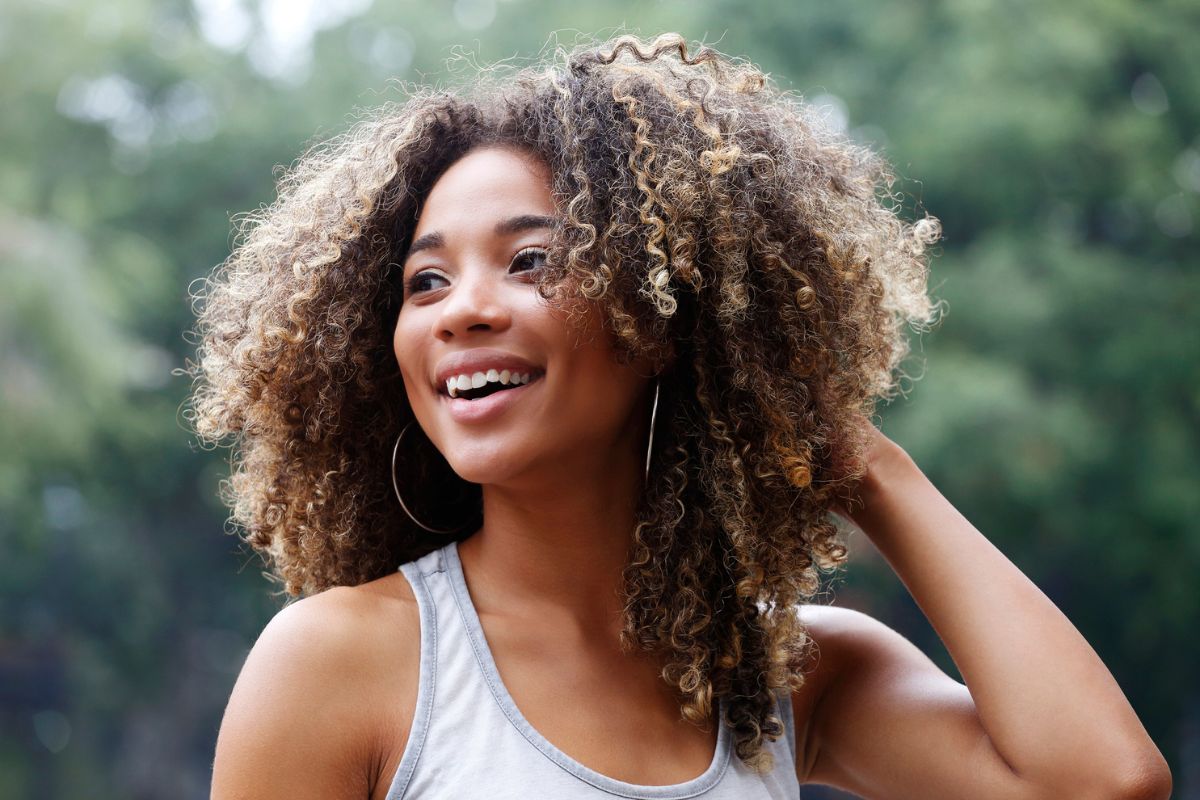 mulher de cabelos cacheados sorrindo