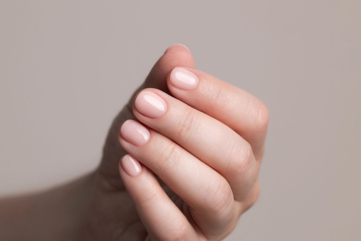 mão com unhas rosadas