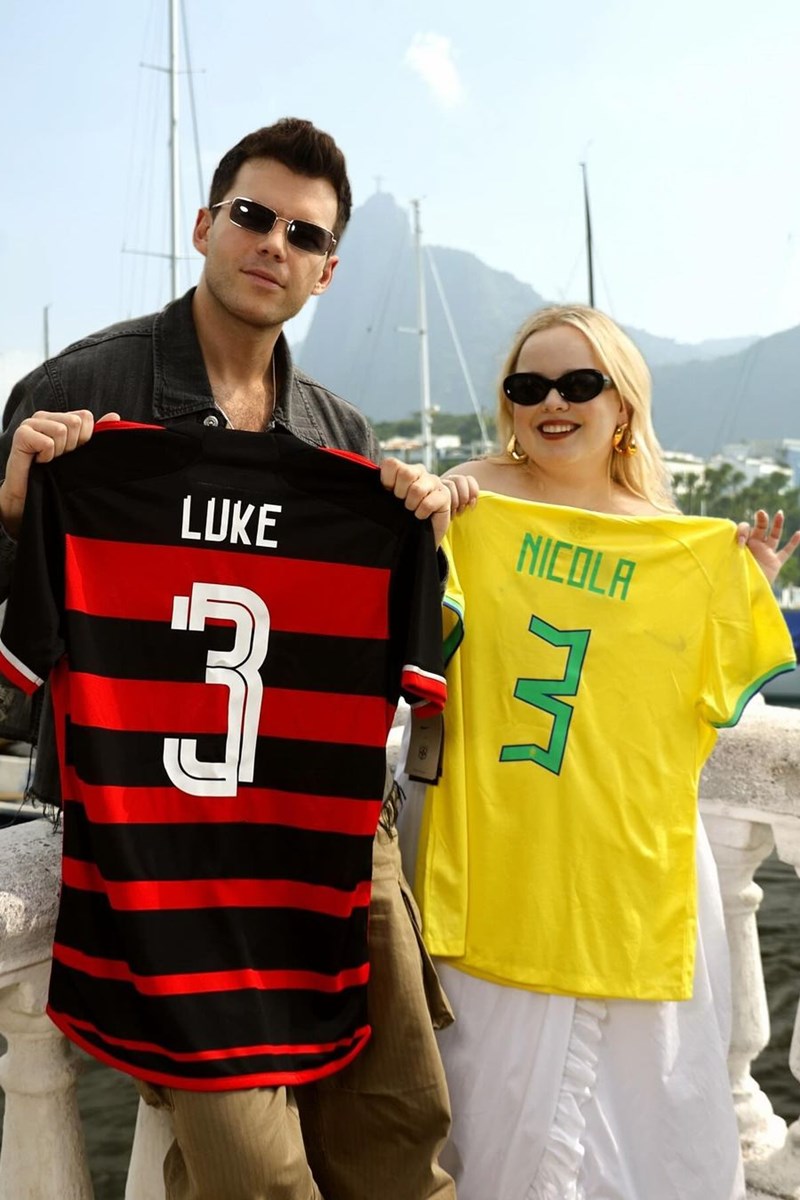 Foto colorida de homem segurando uma camiseta do Flamengo ao lado de mulher com uma camiseta da Seleção Brasileira - Metrópoles