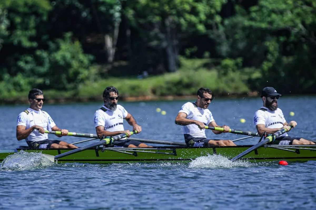 Foto colorida de grupo de pessoas remando em lago - Metrópoles