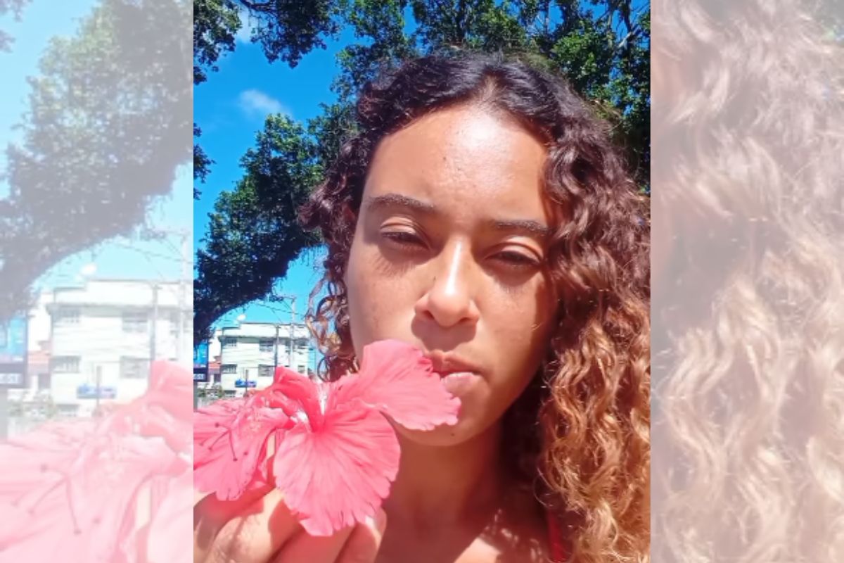 Foto colorida de uma mulher comendo flor - Metrópoles