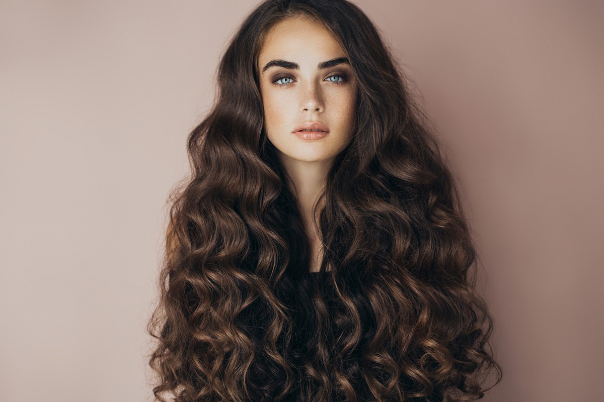 Foto colorida de mulher com o cabelo grande cacheado - Metrópoles