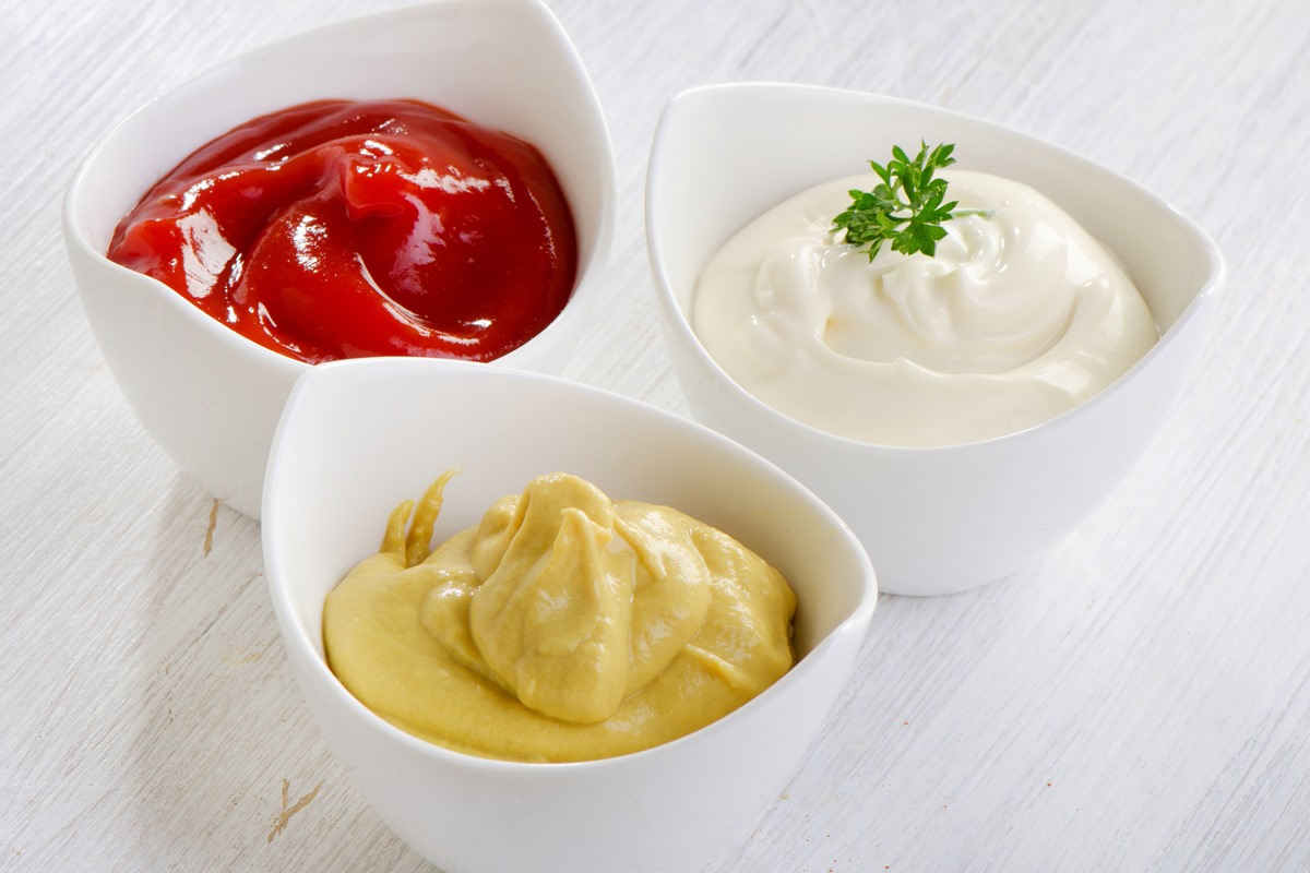 Foto colorida de potes com ketchup, mostarda e maionese - Metrópoles