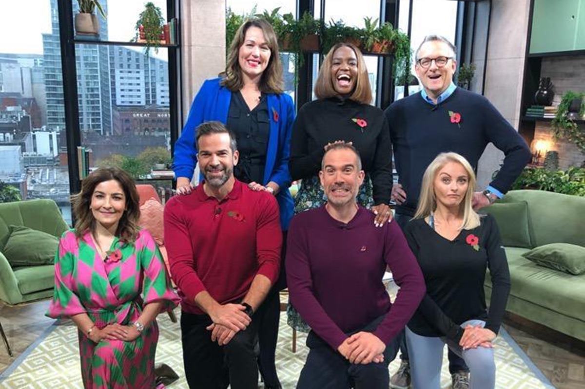 Foto de grupo de pessoas homens e mulheres posando para fotografia. Alguns em pé e outros agachados - Metrópoles