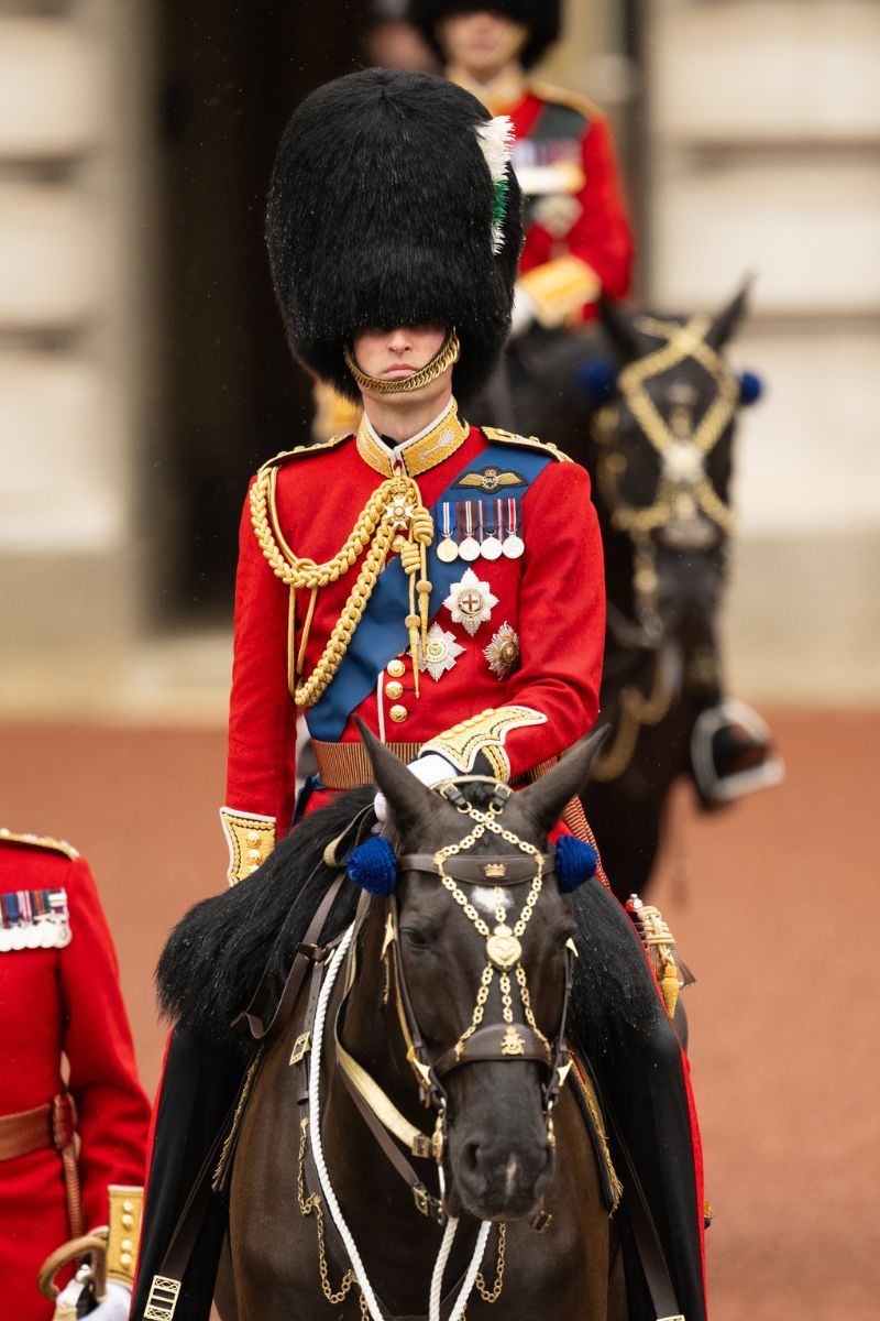 Foto colorida - William a cavalo com traje vermelho