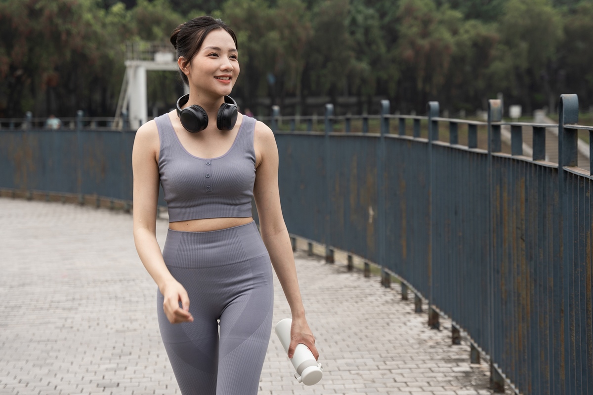 Foto de uma mulher asiática fazendo caminhada, exercício que impulsiona o emagrecimento, no parque - Metrópoles