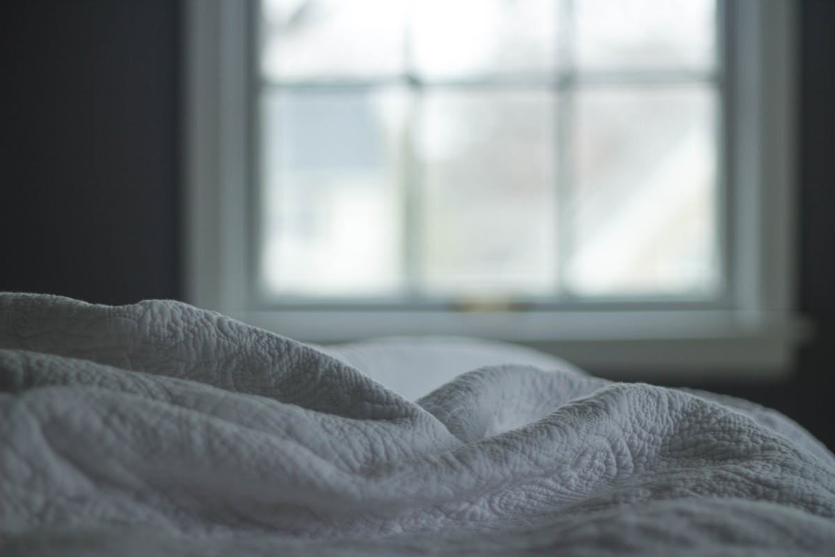 Cobertor de cama com janela ao fundo - Metrópoles