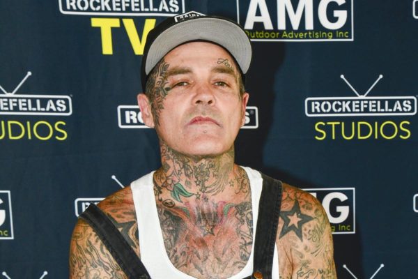 Na foto colorida, cantor Shifty Shellshock aparece de boné e macacão cheio de tatuagens - Metrópoles