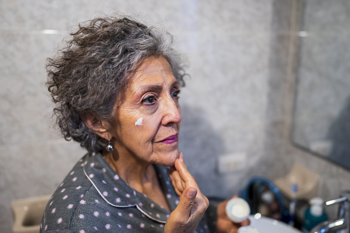 Foto colorida de mulher passando protetor solar - Metrópoles