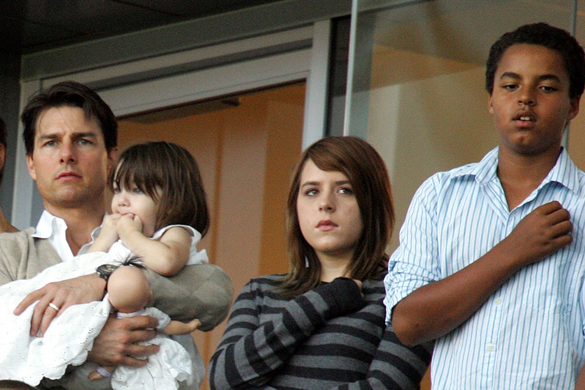Foto colorida - O ator Tom Cruise ao lado dos três filhos, uma bebê no colo e os outros em pé 