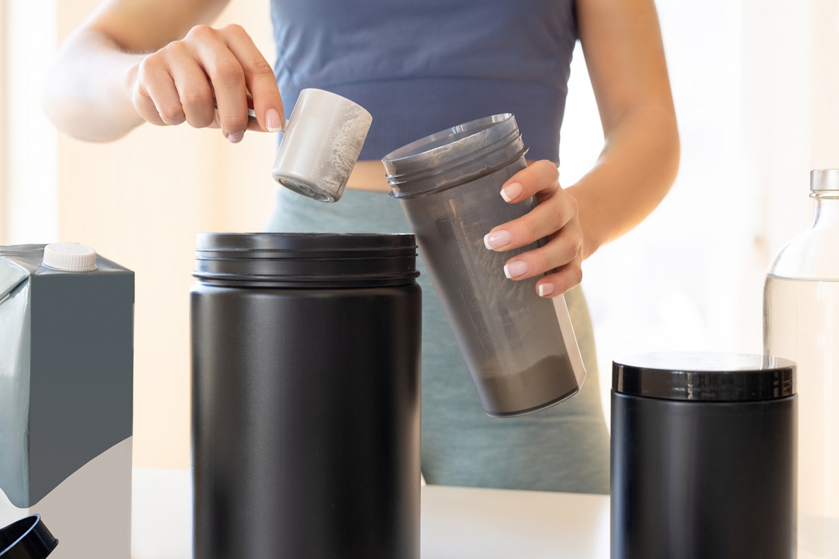 Foto de stock de Mulher que prepara shake de proteína em casa