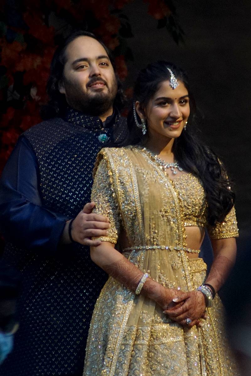 Foto colorida de homem e mulher com trajes indianos posando para fotografia - Metrópoles