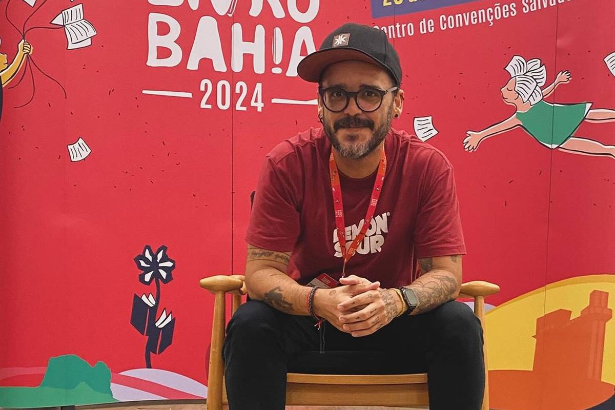 Ian Fraser em foto sentado na Bienal do Livro da Bahia em 2024 - Metrópoles