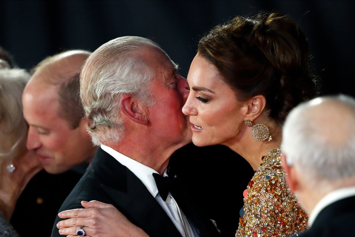 Foto colorida de homem de fraque beijando mulher no rosto - Metrópoles