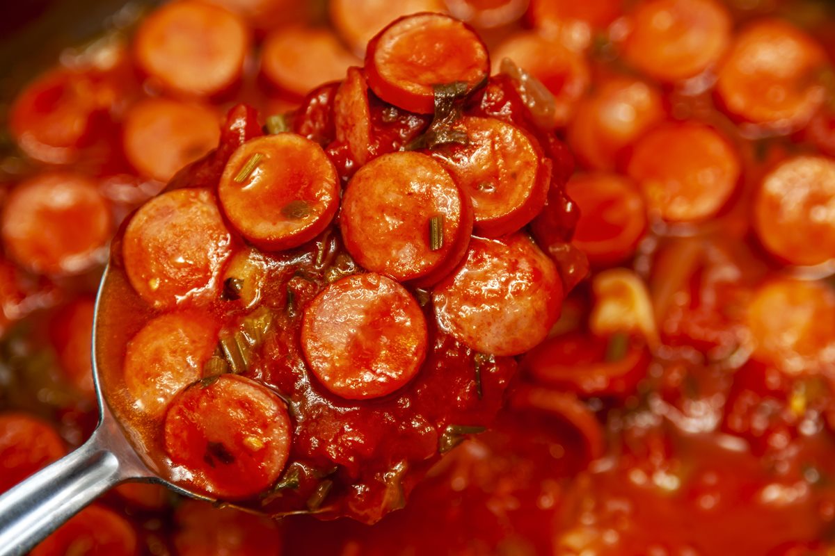 Foto colorida de salsicha em molho de tomate - Metrópoles