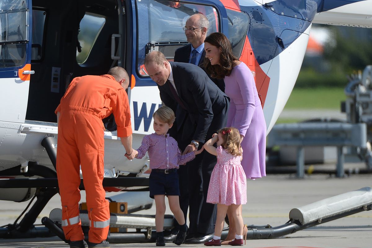 Foto colorida de crianças e adultos perto de um helicóptero - Metrópoles