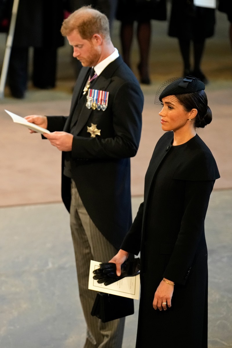 Foto colorida de homem de fraque com papel na mão. Ele está ao lado de mulher com roupa preta - Metrópoles