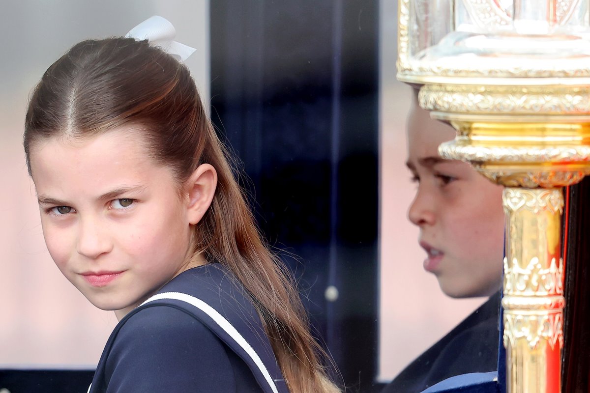 Foto colorida de menina olhando para câmera e atrás dela, tem um menino concentrado - Metrópoles