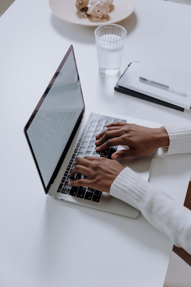 Mãos negras digitando em notebook - Metrópoles