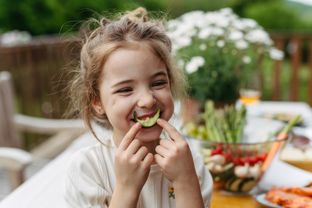 Foto colorida - criança comendo pepino