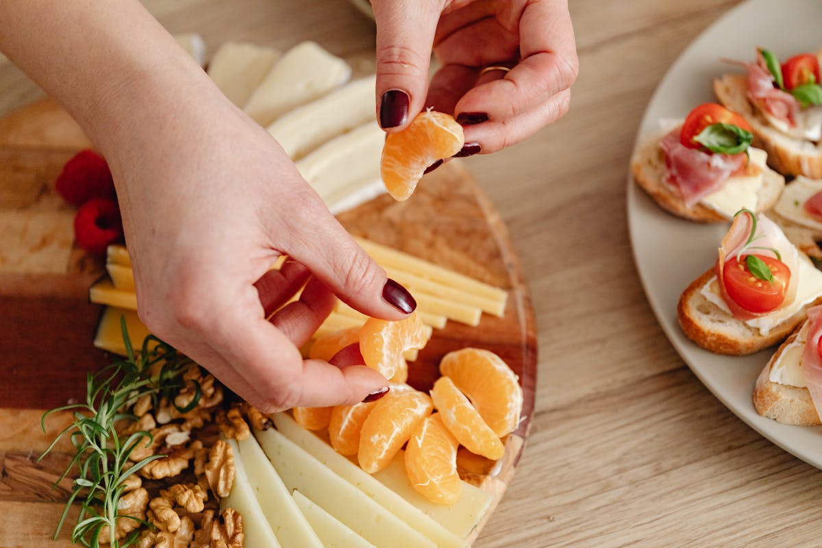 Dedos de mulher montando tábua de antepastos - Metrópoles