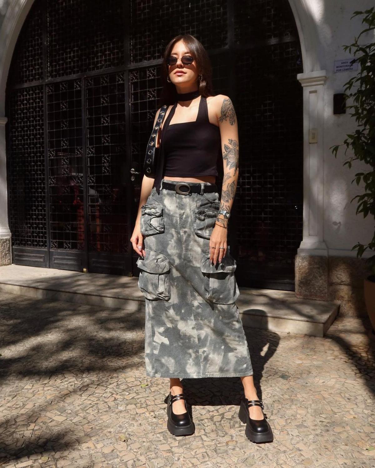 Na imagem com cor, foto de uma influencer com peça em estampa camuflada, tendência de moda que retornou recentemente - metrópoles