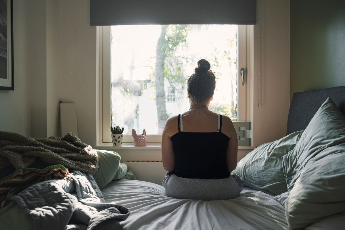 Foto colorida de uma jovem na cama - Metrópoles