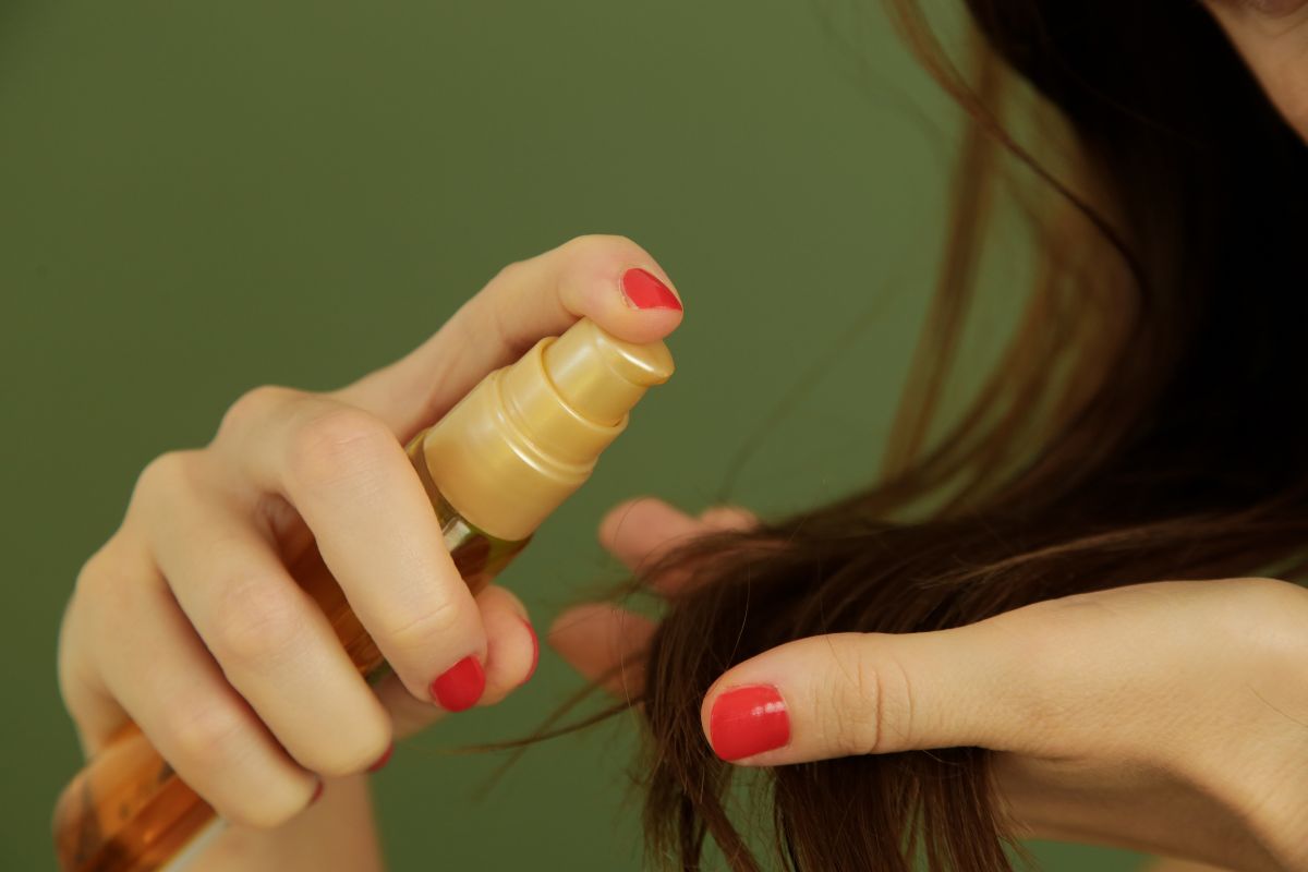 mulher aplicando óleo no cabelo