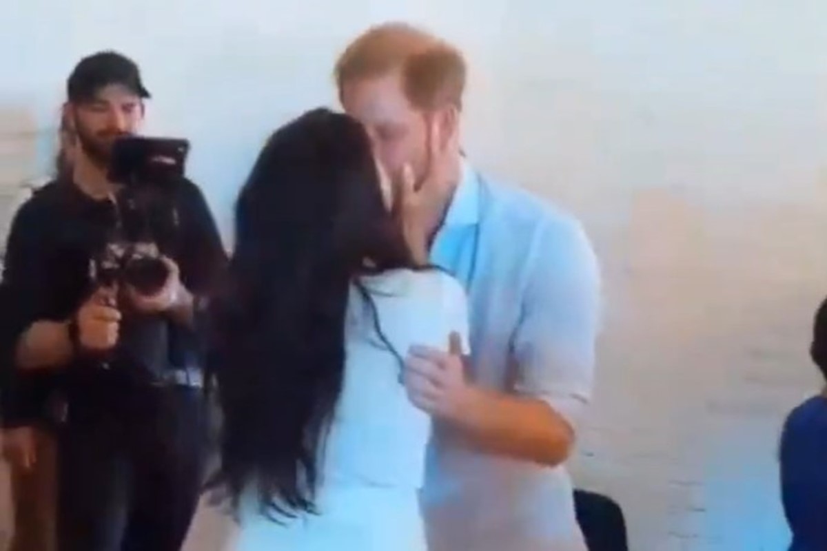 Foto colorida: Harry e Meghan aos beijos 