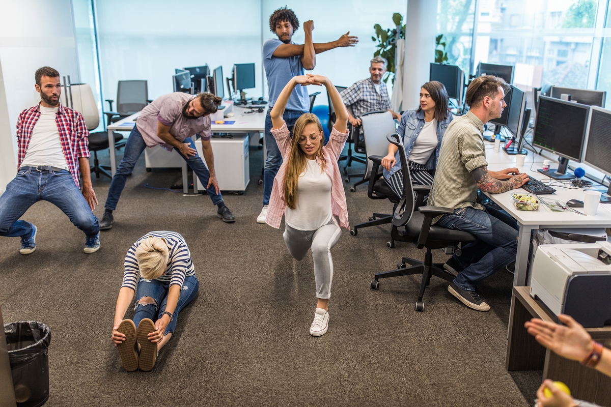 Foto colorida - pessoas se alongando no trabalho