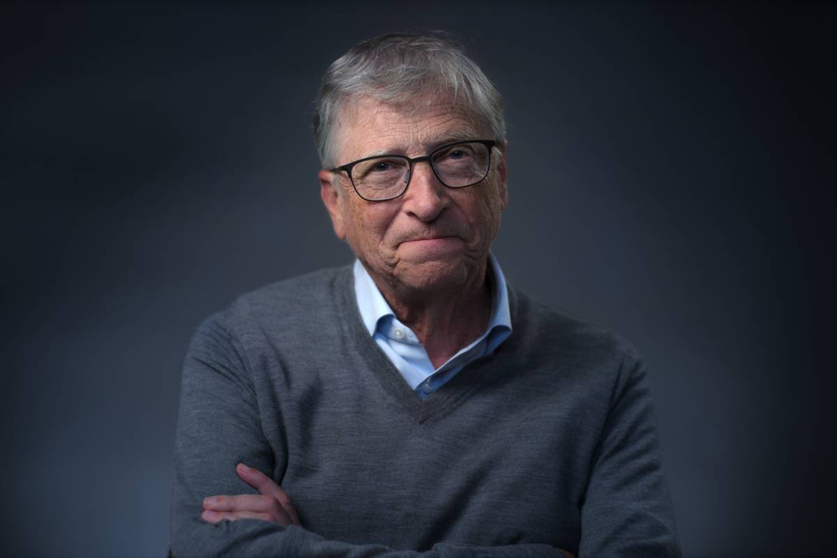 Imagem colorida de Bill Gates em fundo cinza, sorrindo e usando óculos - Metrópoles