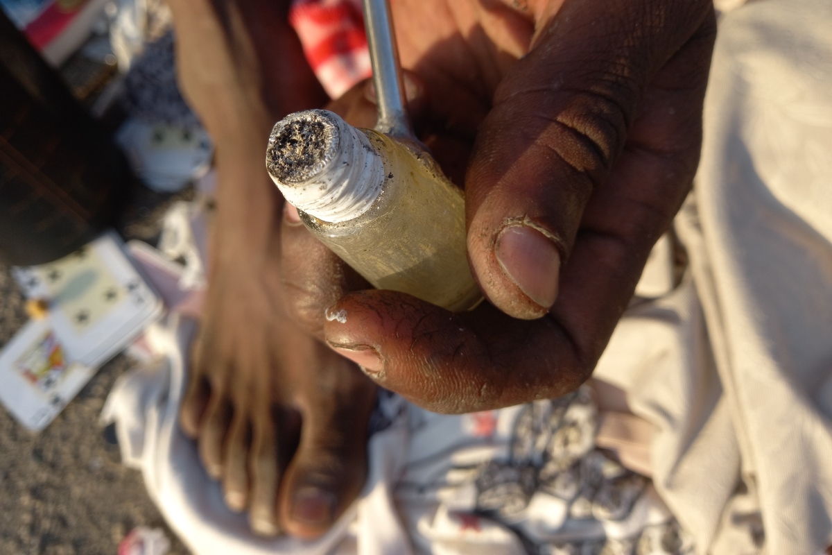 Imagem mostra mão segurando cachimbo de crack - Metrópoles