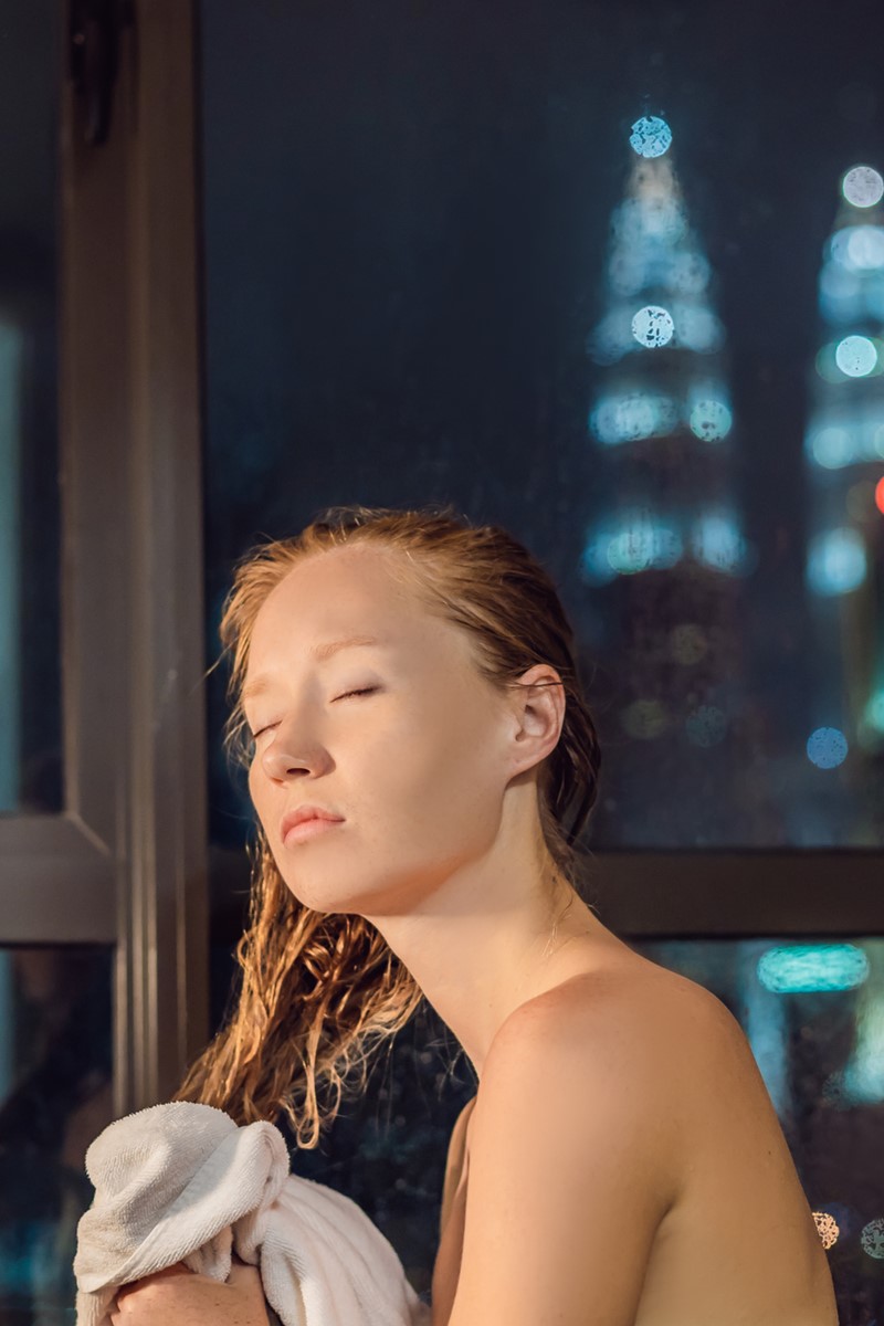 Foto colorida de mulher passando a toalha no cabelo - Metrópoles