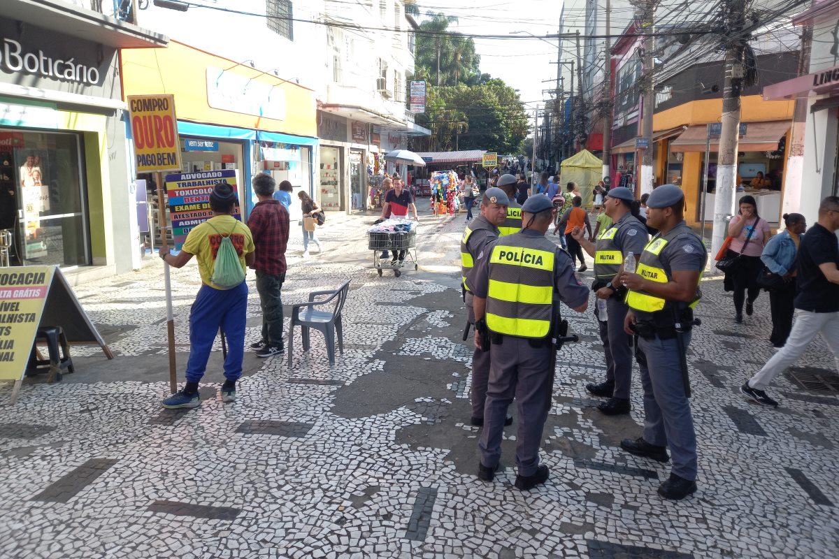 Imagem mostra pedestres e policiais militares em calçadão - Metrópoles