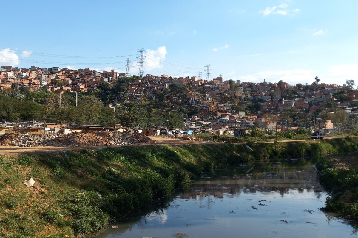 Imagem mostra córrego e casas - Metrópoles