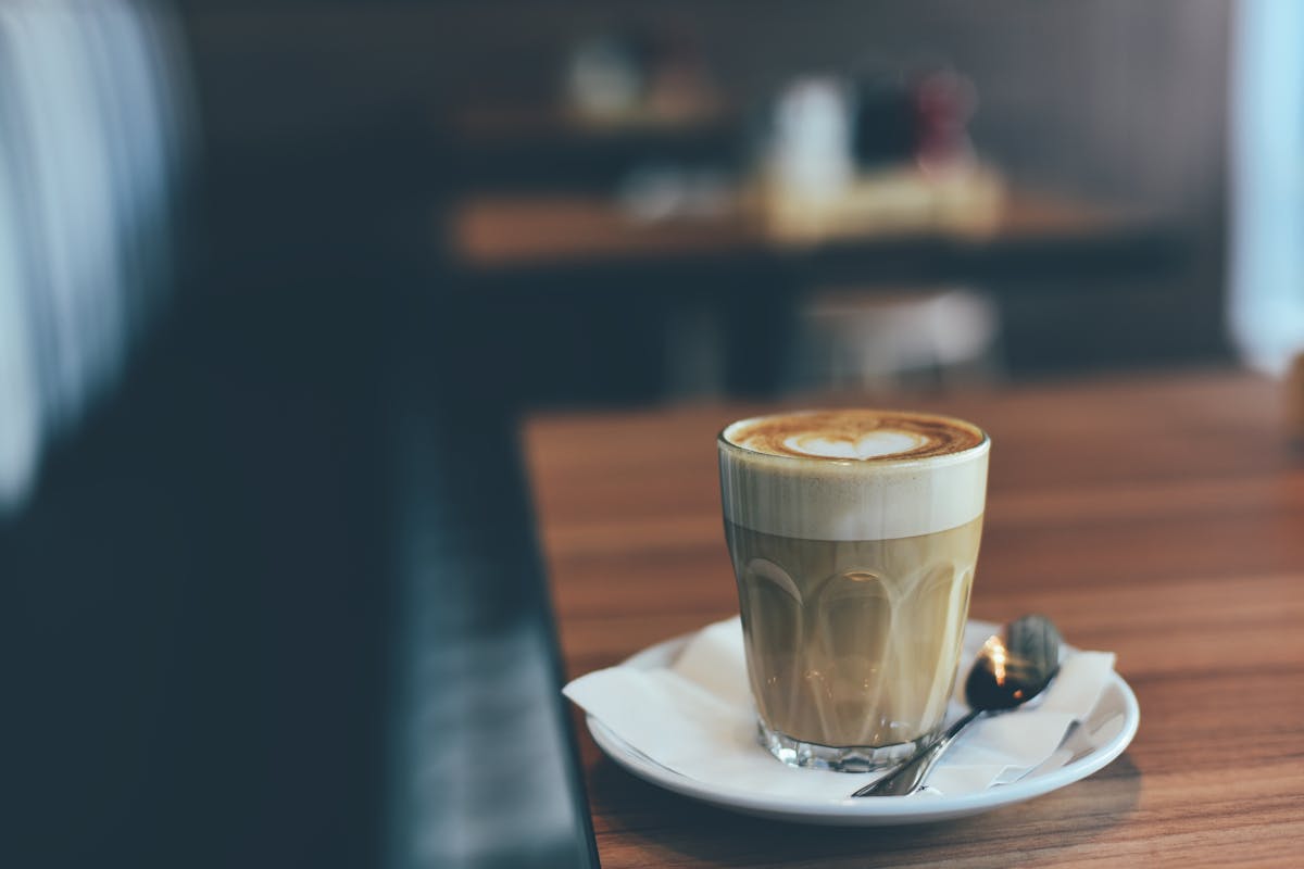 Copo de shake de café em mesa de madeira - Metrópoles