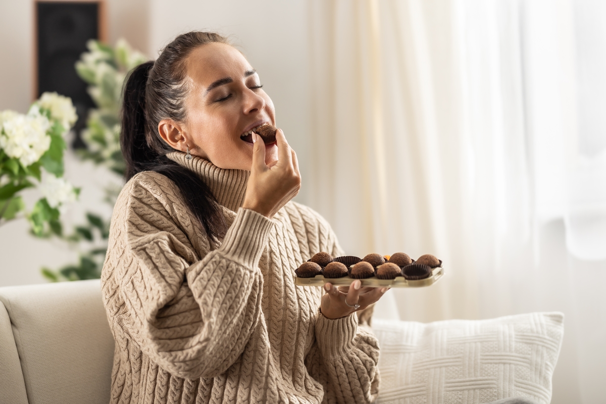 Foto colorida - mulher comendo chocolate