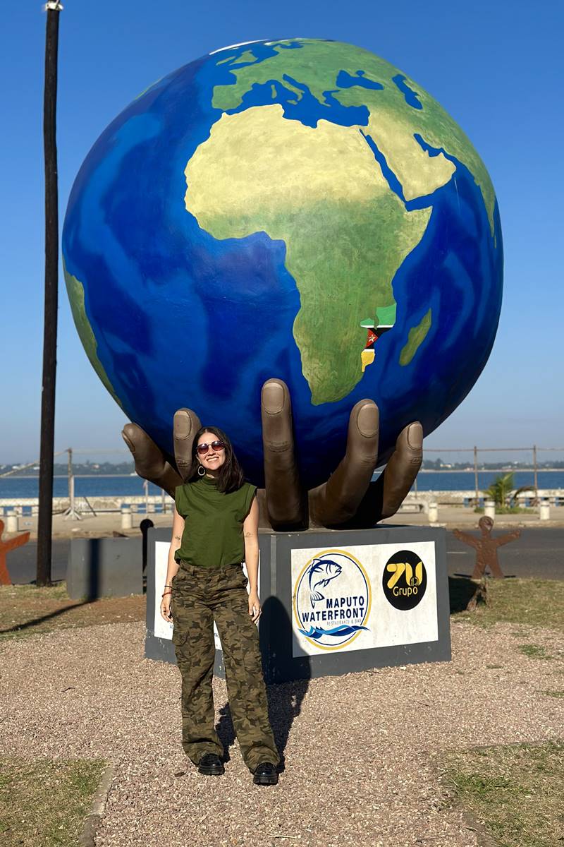 Foto colorida de mulher perto de escultura de globo - Metrópoles