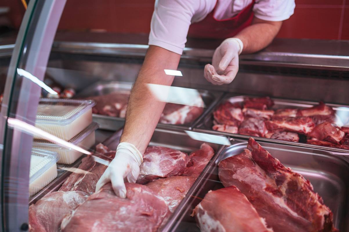 Imagem colorida de pessoa segurando carnes - Metrópoles