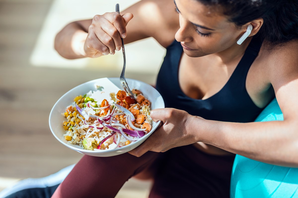 Foto colorida de mulher comendo - Metrópoles