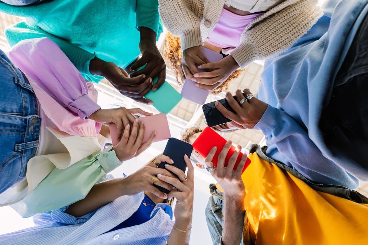 Imagem colorida de jovens mexendo nas redes sociais juntos - Metrópoles