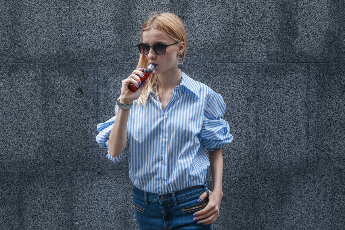 Foto colorida de mulher fumando vape - Metrópoles