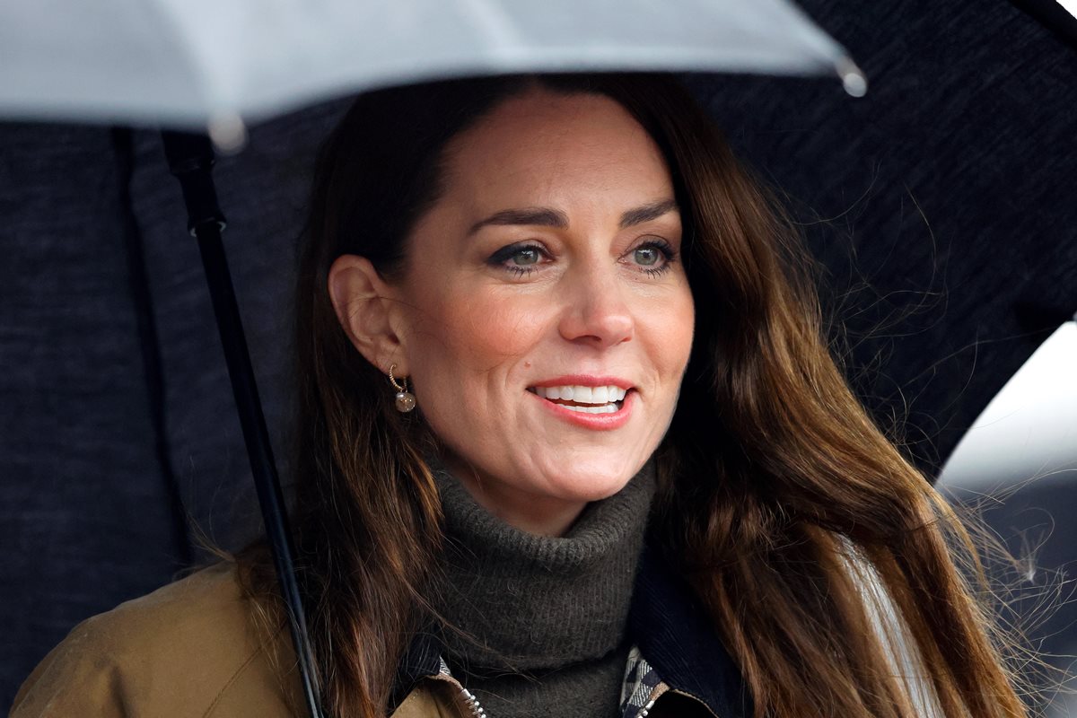 Foto colorida de mulher segurando um guarda-chuva. Ela está com o cabelo solto - Metrópoles