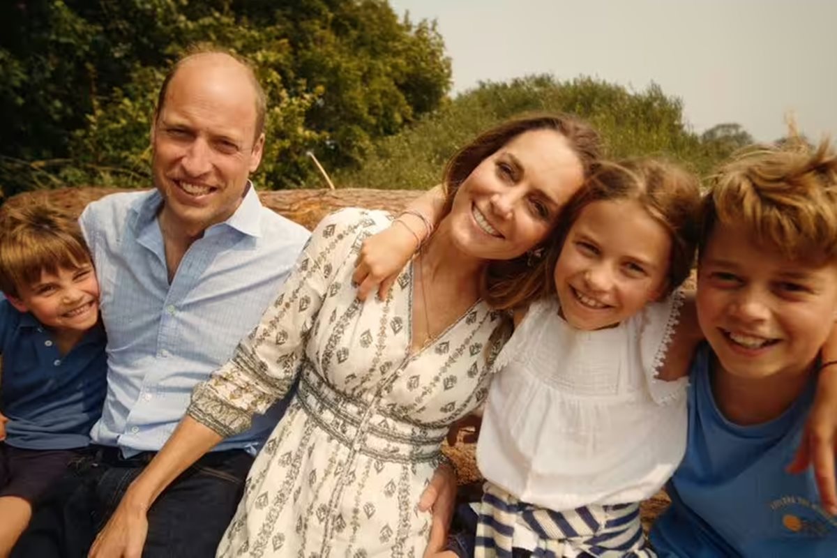 Foto colorida de crianças abraçadas a um homem e uma mulher - Metrópoles