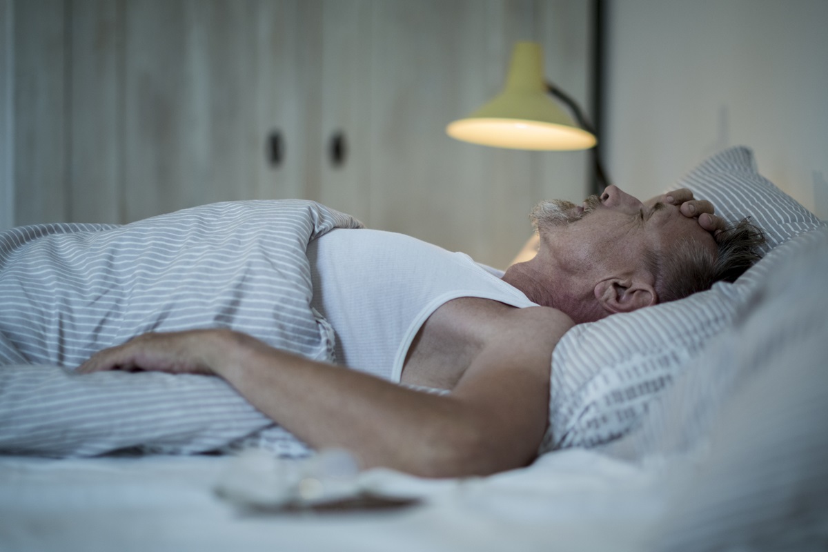 Foto colorida de homem deitada em cama - Metrópoles